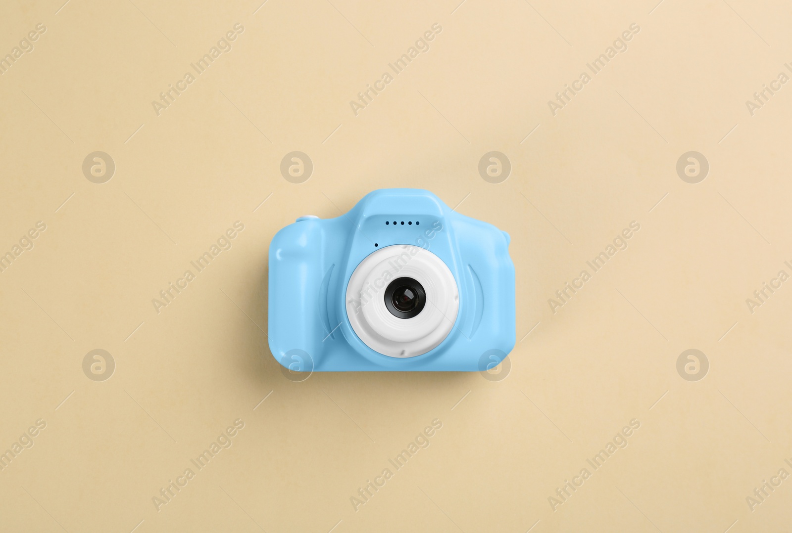 Photo of Light blue toy camera on beige background, top view