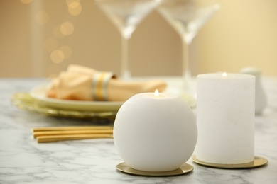 Photo of Burning candles on served white marble table