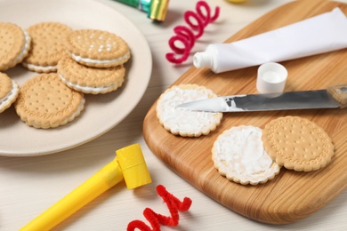 Photo of Cookies with toothpaste on white wooden table. April fool's day