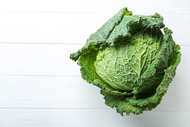 Photo of Fresh ripe savoy cabbage on white wooden table, top view. Space for text