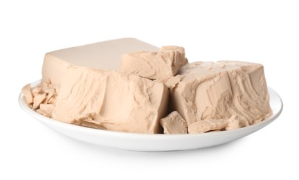 Plate with pieces of compressed yeast on white background