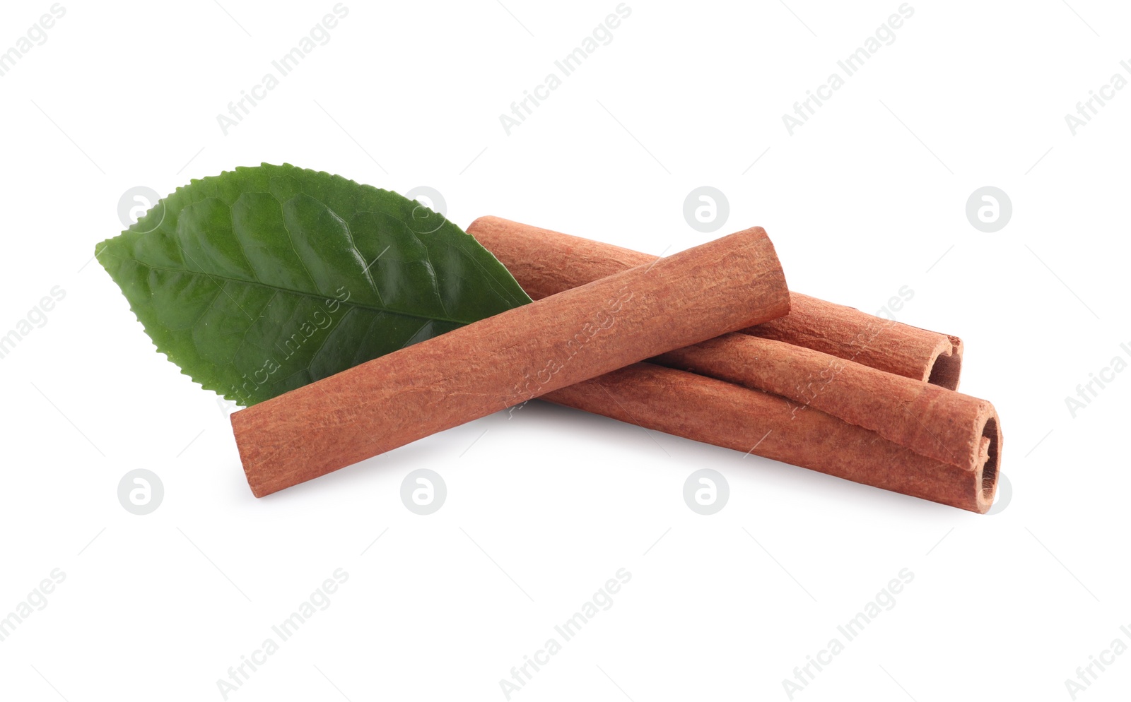 Photo of Aromatic cinnamon sticks and green leaf isolated on white