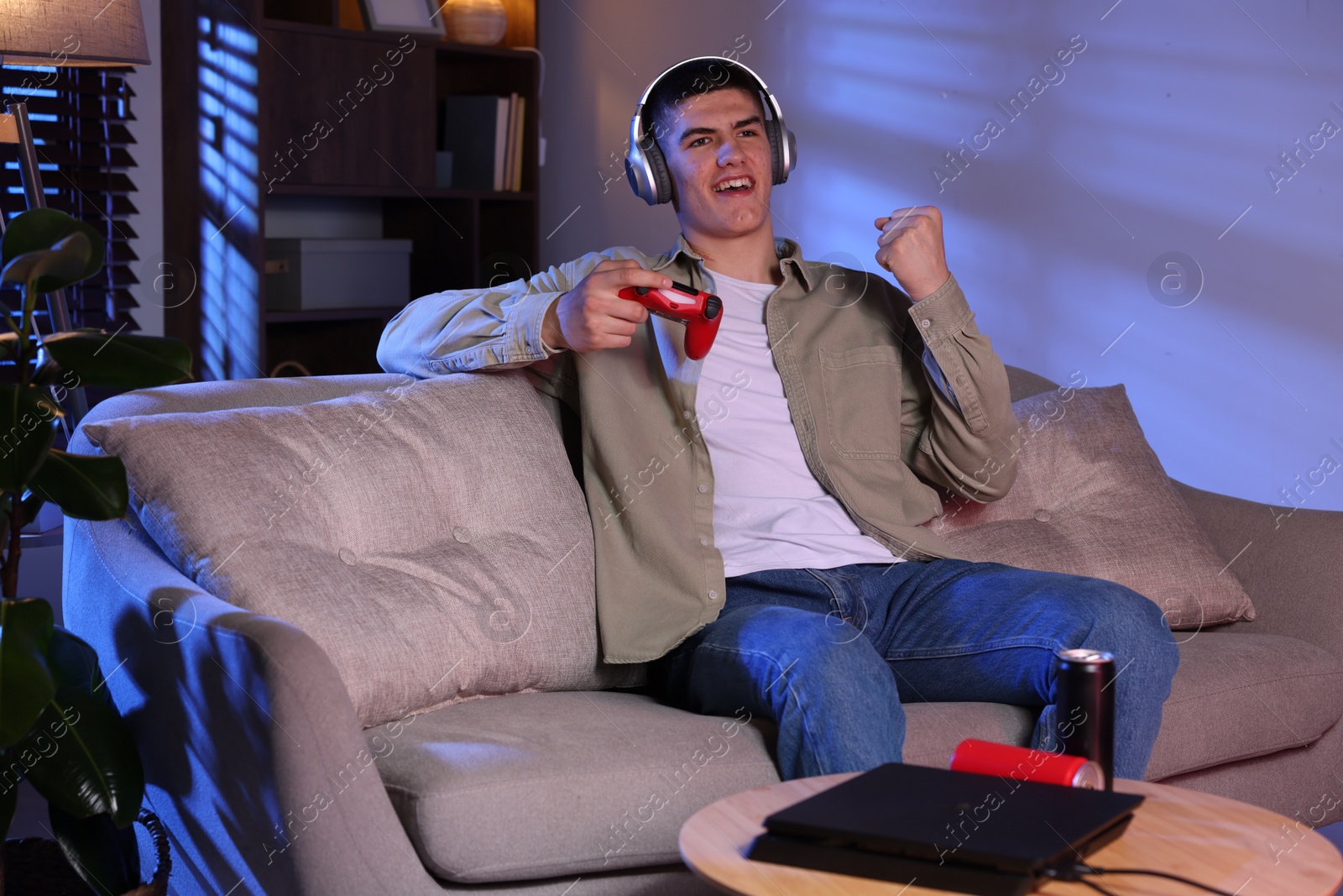 Photo of Emotional man playing video games with controller at home