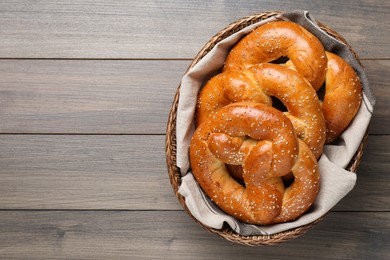 Photo of Basket with delicious pretzels on wooden table, top view. Space for text