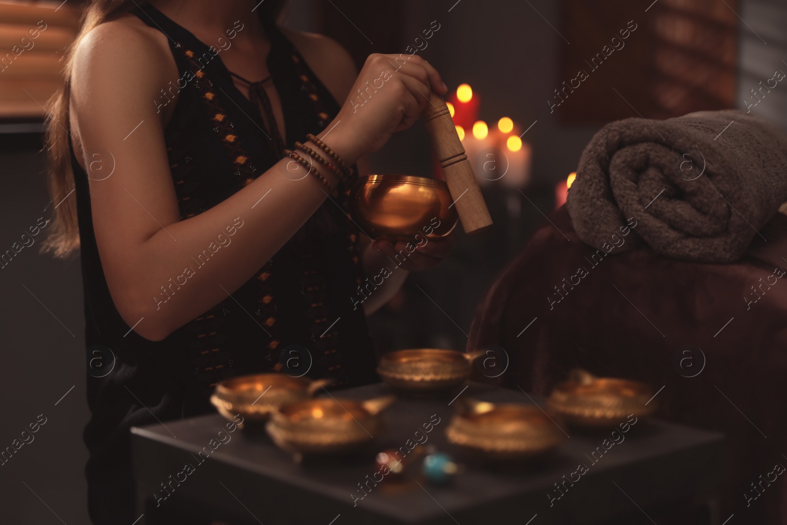 Photo of Healer using singing bowl in dark room, closeup