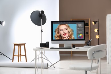 Photo of Retoucher's workplace. Computer with photo editor application, camera and graphic tablet on table in studio