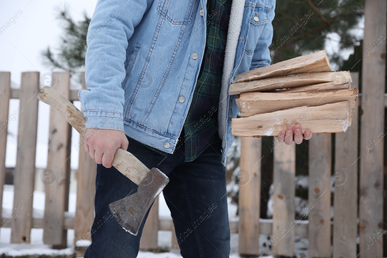 Photo of Man with axe and wood outdoors on winter day, closeup