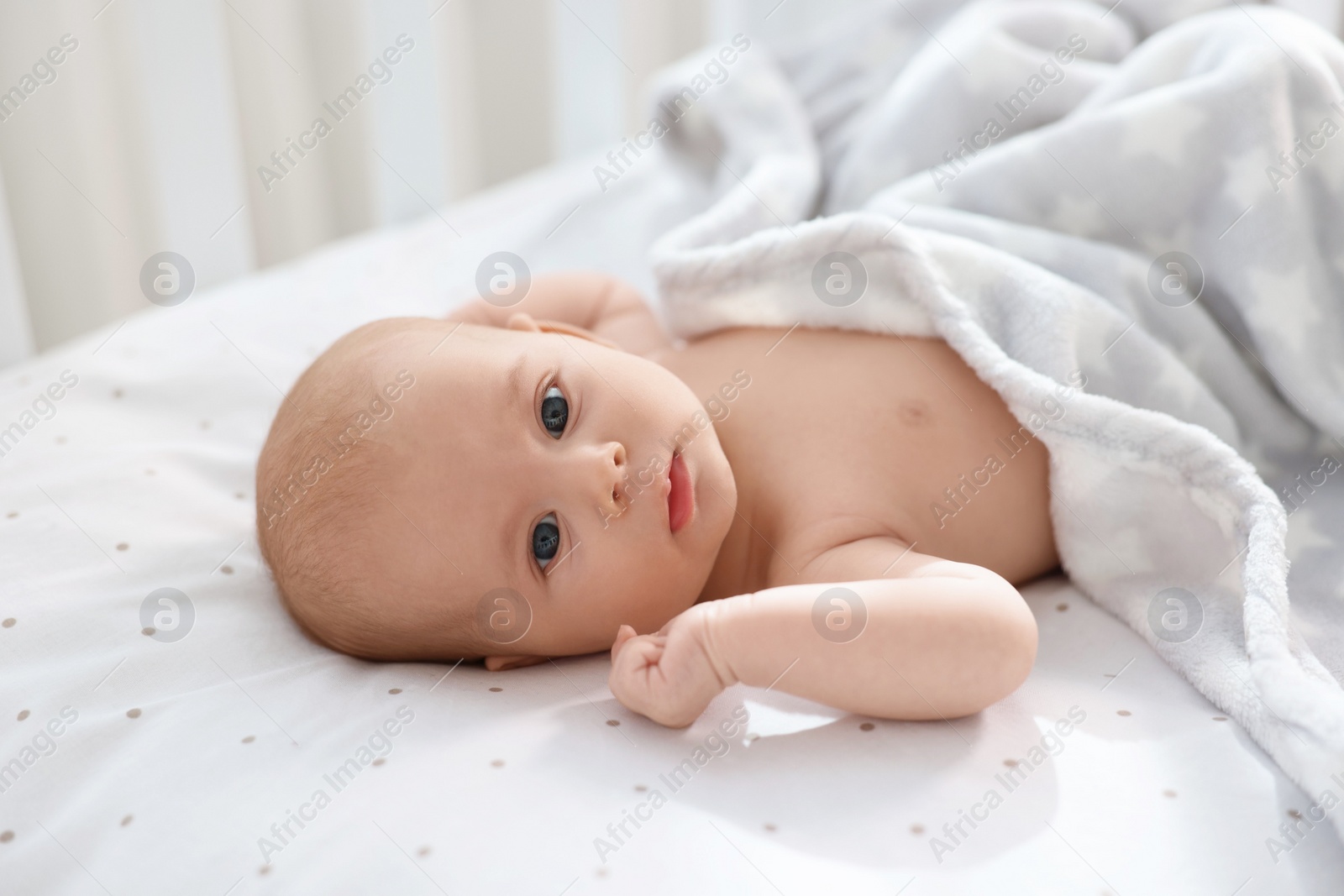 Photo of Cute little baby lying in crib at home