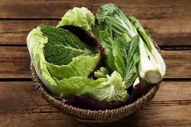 Photo of Many different cabbage leaves on wooden table