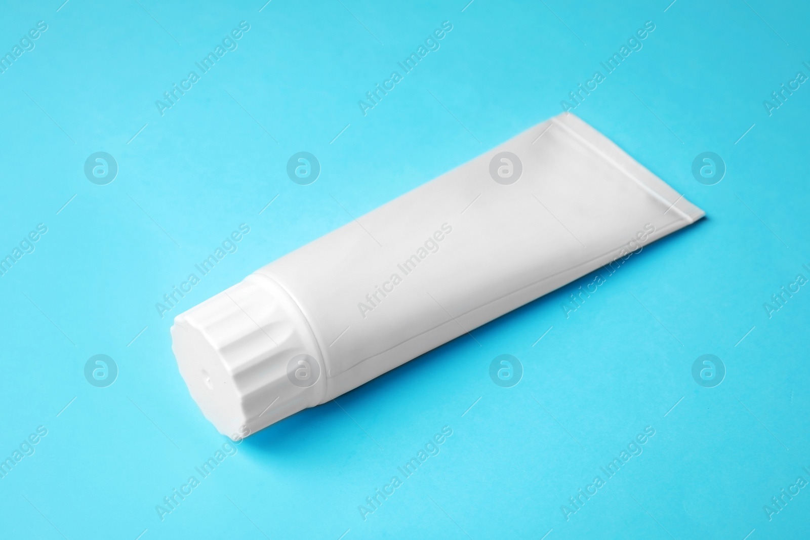 Photo of Blank tube of toothpaste on color background