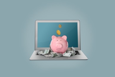 Image of Piggy bank with money and laptop on light blue background. Online banking