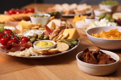 Photo of Assorted appetizers served on wooden table, closeup