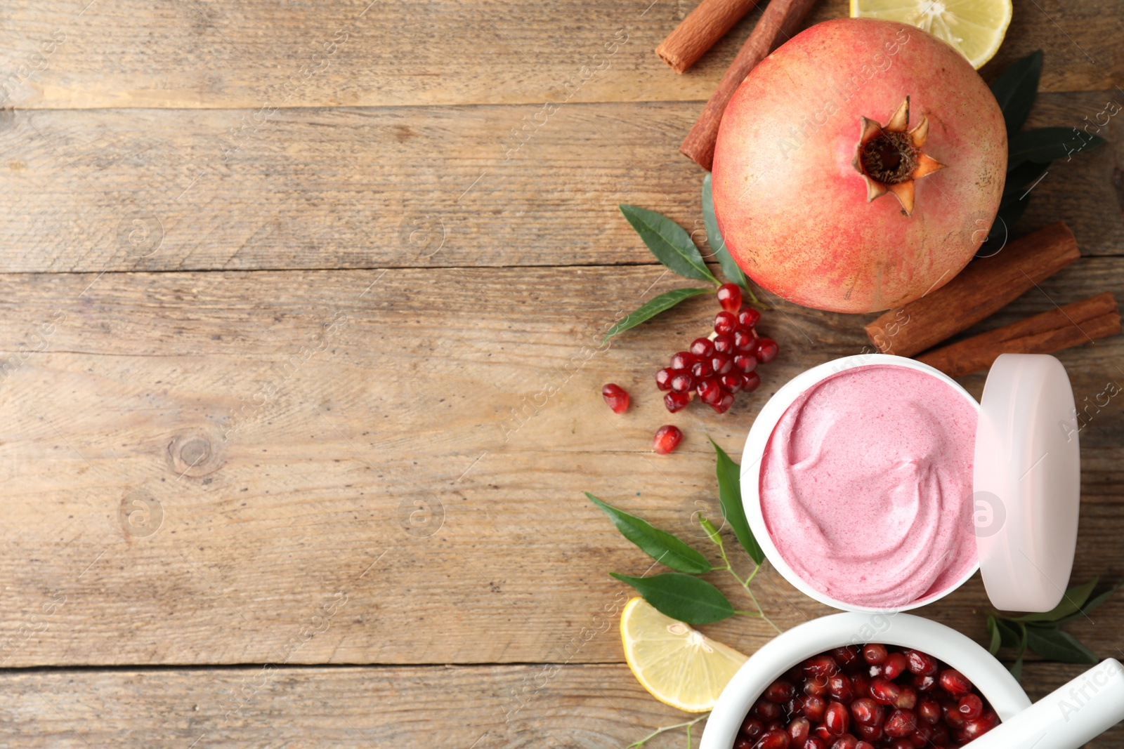 Photo of Flat lay composition with natural homemade mask, pomegranate and ingredients on wooden table. Space for text