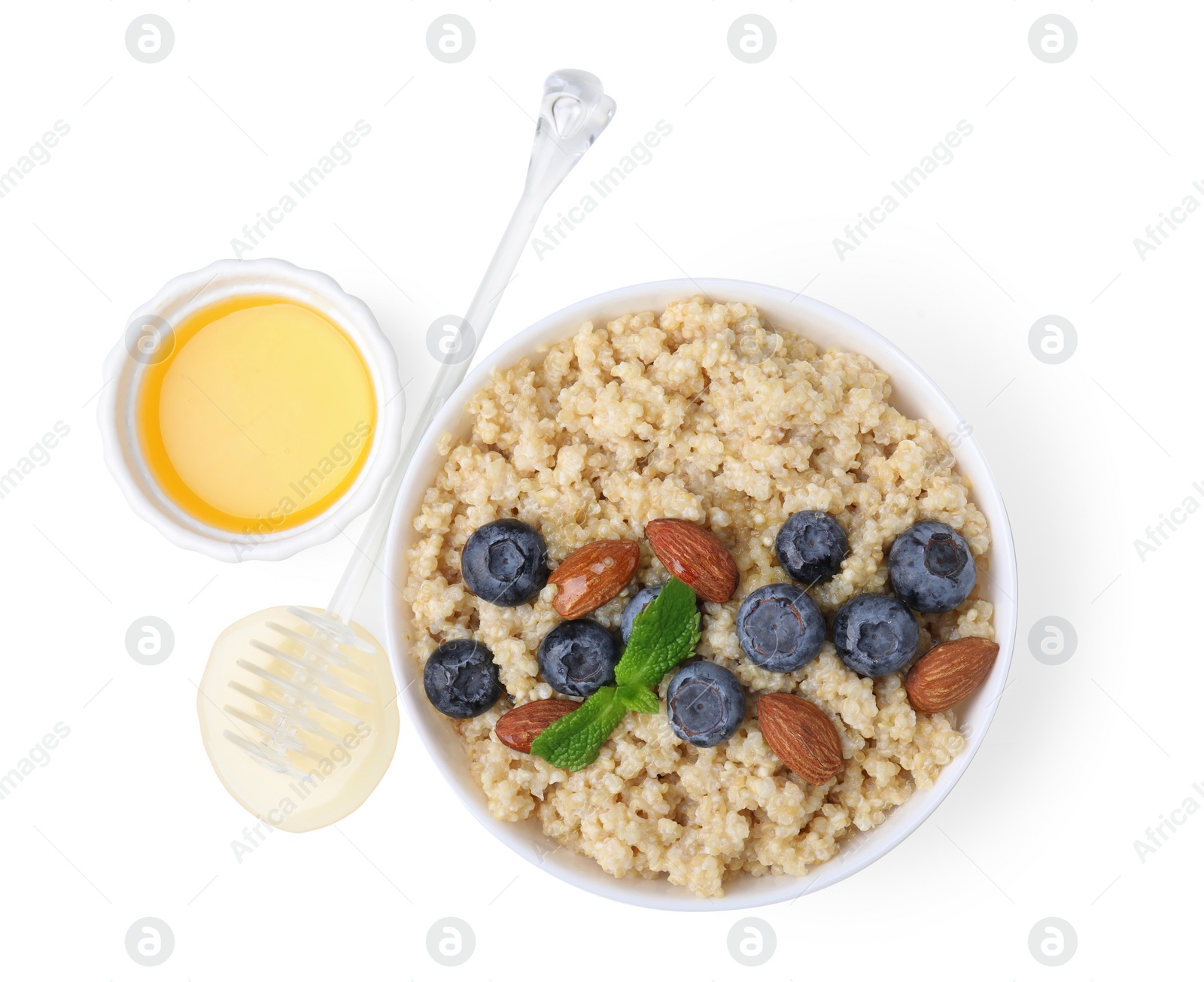 Photo of Bowl of delicious cooked quinoa with almonds, honey and blueberries on white background, top view