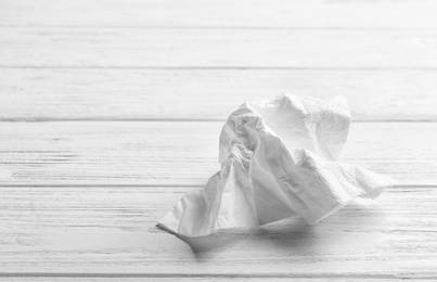 Crumpled napkin on wooden background, space for text. Personal hygiene