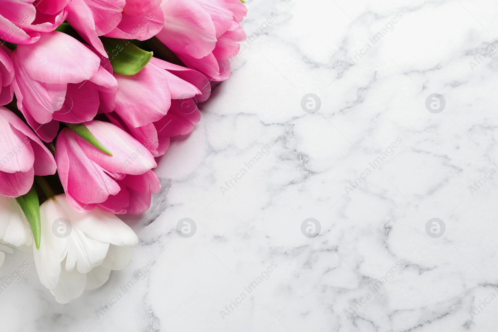 Photo of Beautiful tulips on marble background, top view with space for text. International Women's Day