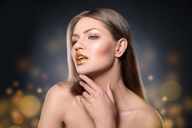 Photo of Portrait of beautiful lady with gold lipstick against blurred lights