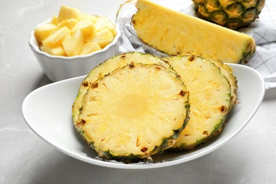 Plate with fresh sliced pineapple on table