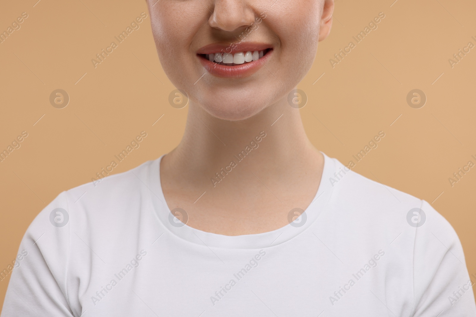 Photo of Beauty concept. Smiling woman on beige background, closeup