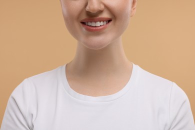 Photo of Beauty concept. Smiling woman on beige background, closeup