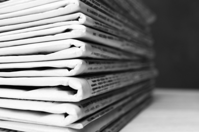 Photo of Stack of newspapers on white table, closeup. Journalist's work