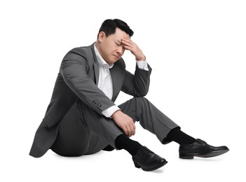 Photo of Tired businessman in suit sitting on white background