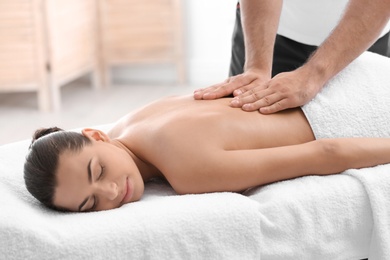 Relaxed woman receiving back massage in wellness center