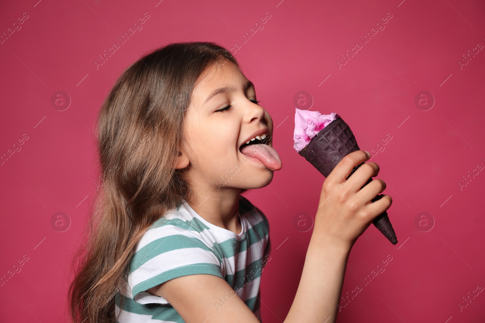 Photo of Adorable little girl with delicious ice cream against color background