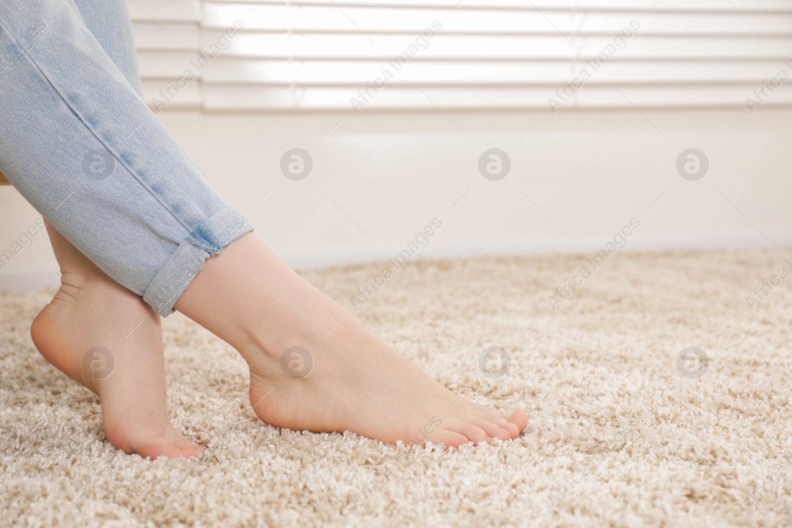 Photo of Woman sitting on soft carpet at home, closeup. Space for text