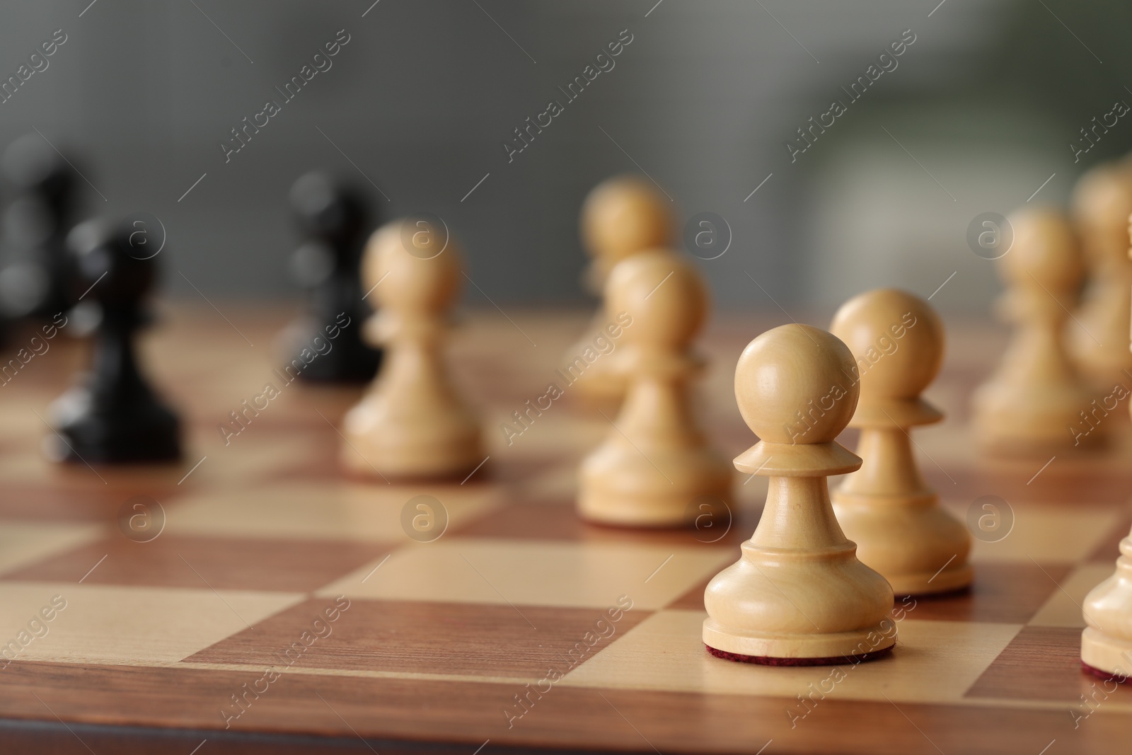 Photo of White wooden pawns on chess board, selective focus. Space for text