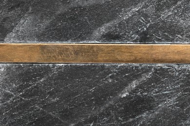 Photo of Texture of black marble surface with wooden plank as background, closeup