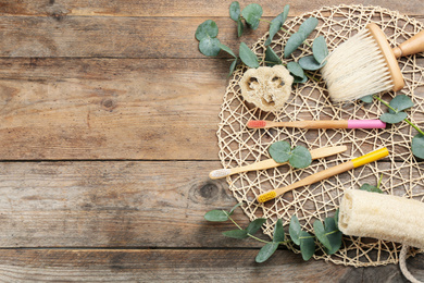 Flat lay composition with bamboo toothbrushes on wooden table. Space for text