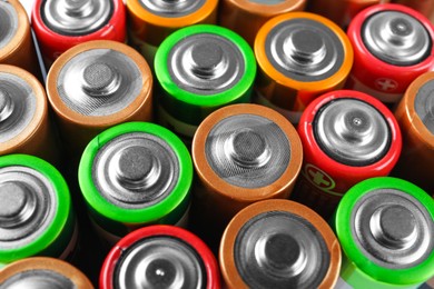 Photo of Many different batteries as background, closeup view
