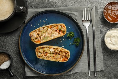 Photo of Pieces of delicious strudel with chicken and vegetables served on grey textured table, flat lay