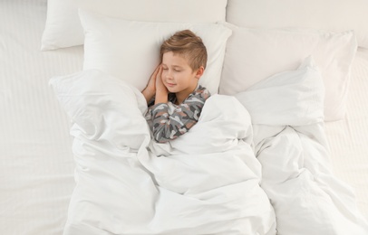 Photo of Cute boy sleeping in bed, above view