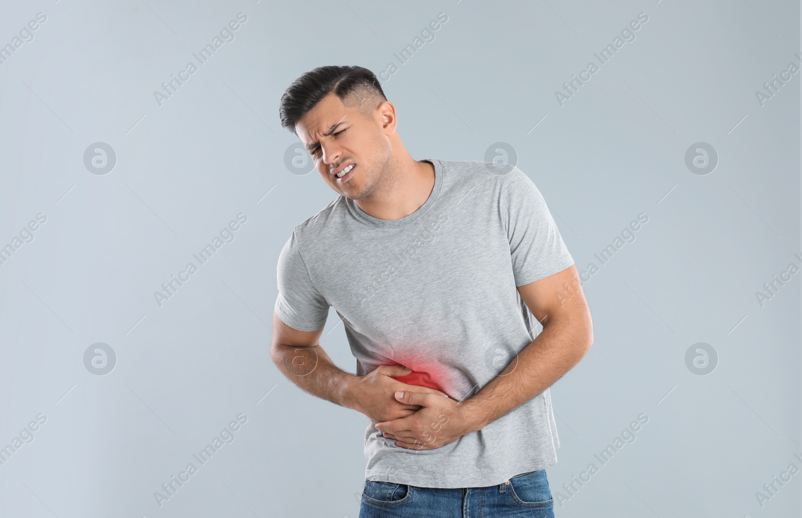 Photo of Man suffering from liver pain on grey background