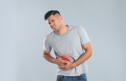 Photo of Man suffering from liver pain on grey background