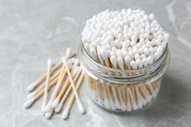 Photo of Many cotton buds on light grey marble table