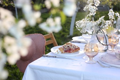 Photo of Stylish table setting with beautiful spring flowers in garden