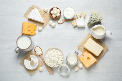 Frame made with different dairy products on white table, top view. Space for text