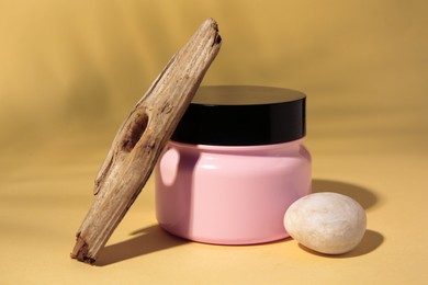 Photo of Jar of cream, stick and stone on beige background
