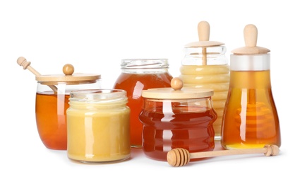 Photo of Glass jars with different types of sweet honey on white background