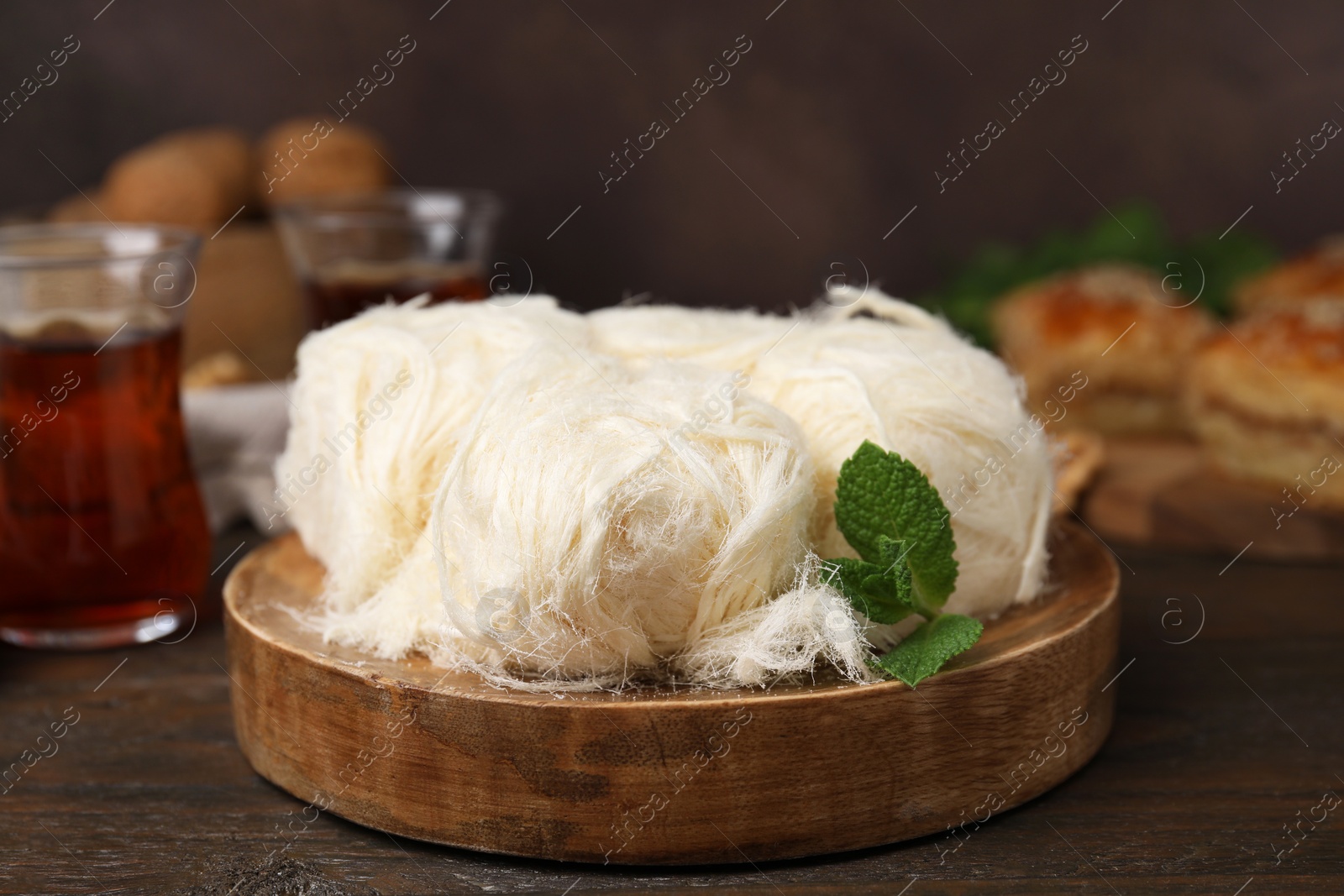 Photo of Eastern sweets. Tasty Iranian pashmak on wooden table, closeup