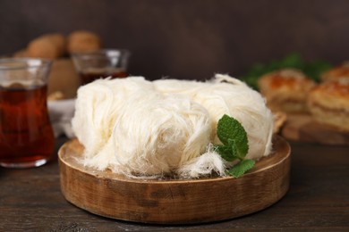 Photo of Eastern sweets. Tasty Iranian pashmak on wooden table, closeup