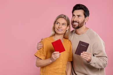 Immigration. Happy couple with passports on pink background, space for text
