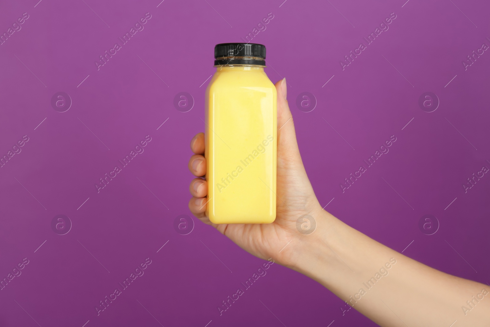 Photo of Woman holding bottle with delicious smoothie on color background