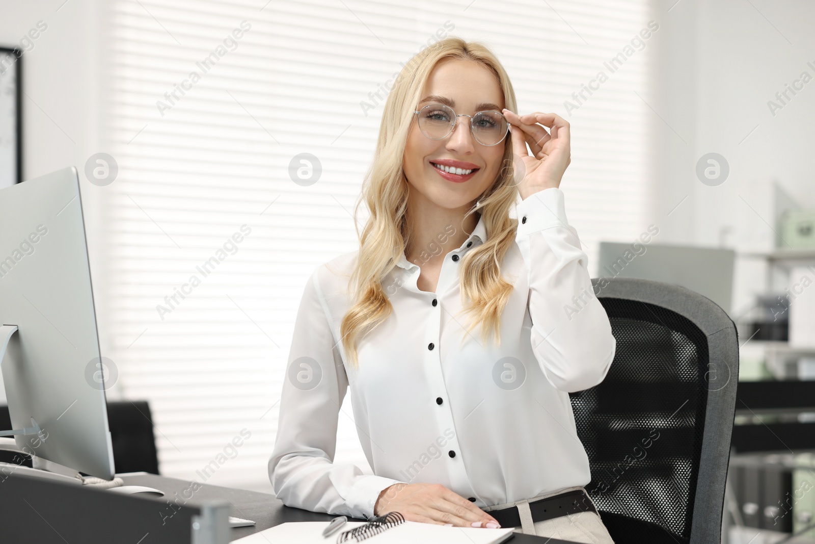 Photo of Happy secretary in glasses at table in office