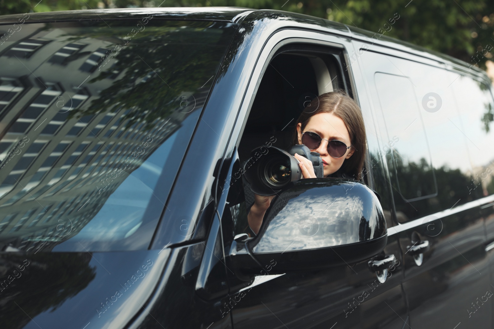 Photo of Private detective with camera spying from car