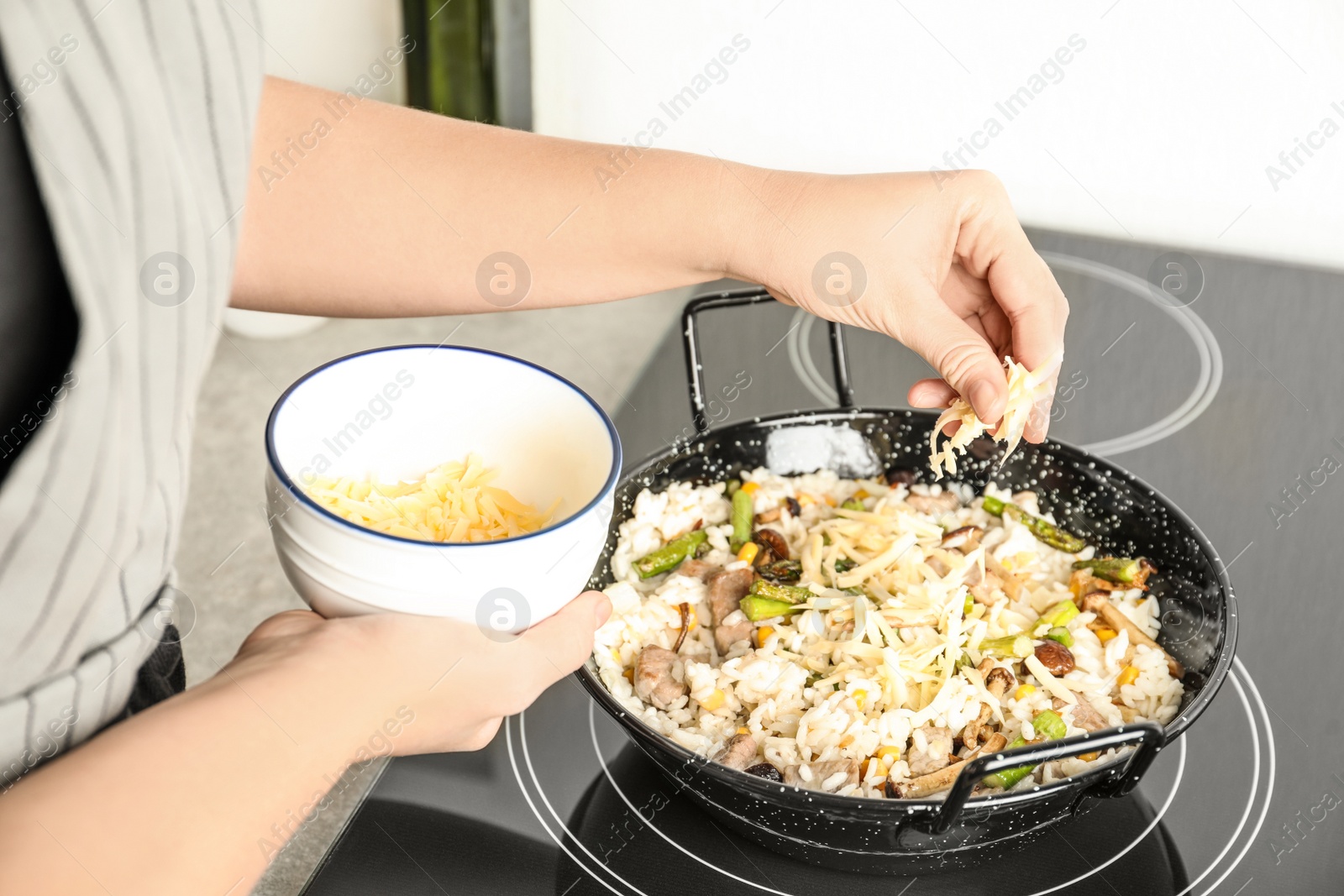 Photo of Woman cooking delicious risotto, closeup. Tasty recipe