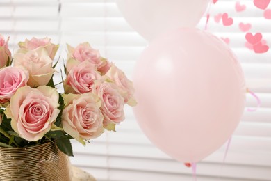 Photo of Beautiful bouquet of rose flowers in vase and air balloons indoors. Happy birthday